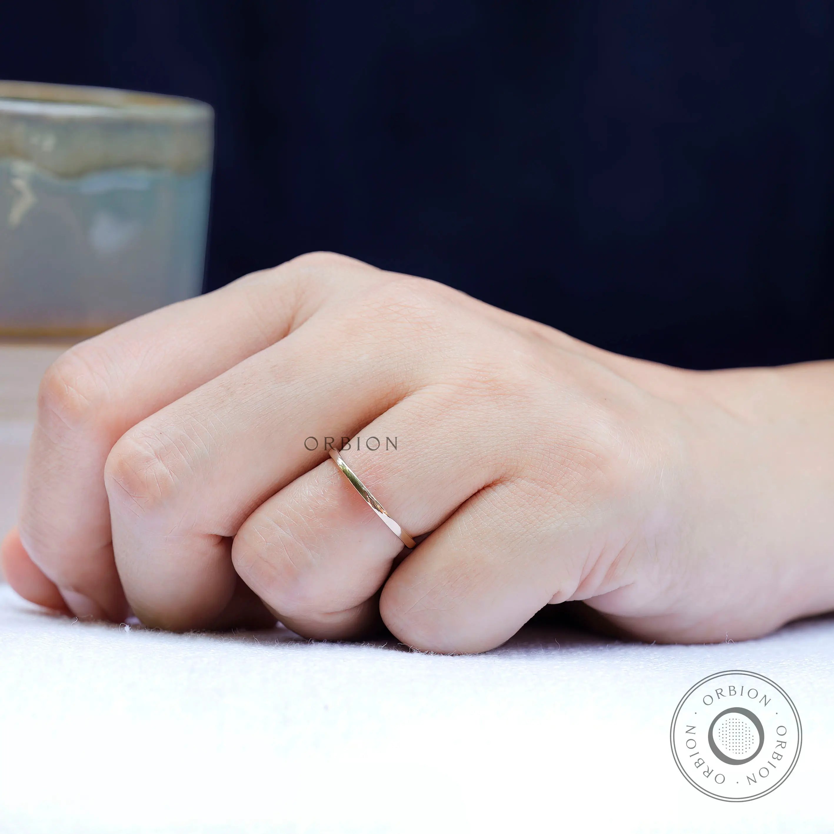 Slim gold band ring shown worn on finger for everyday minimalist styling