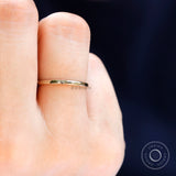 Minimalist plain gold wedding band worn on finger with smooth polished finish