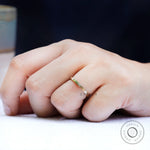 On-hand view of simple yellow gold wedding band
