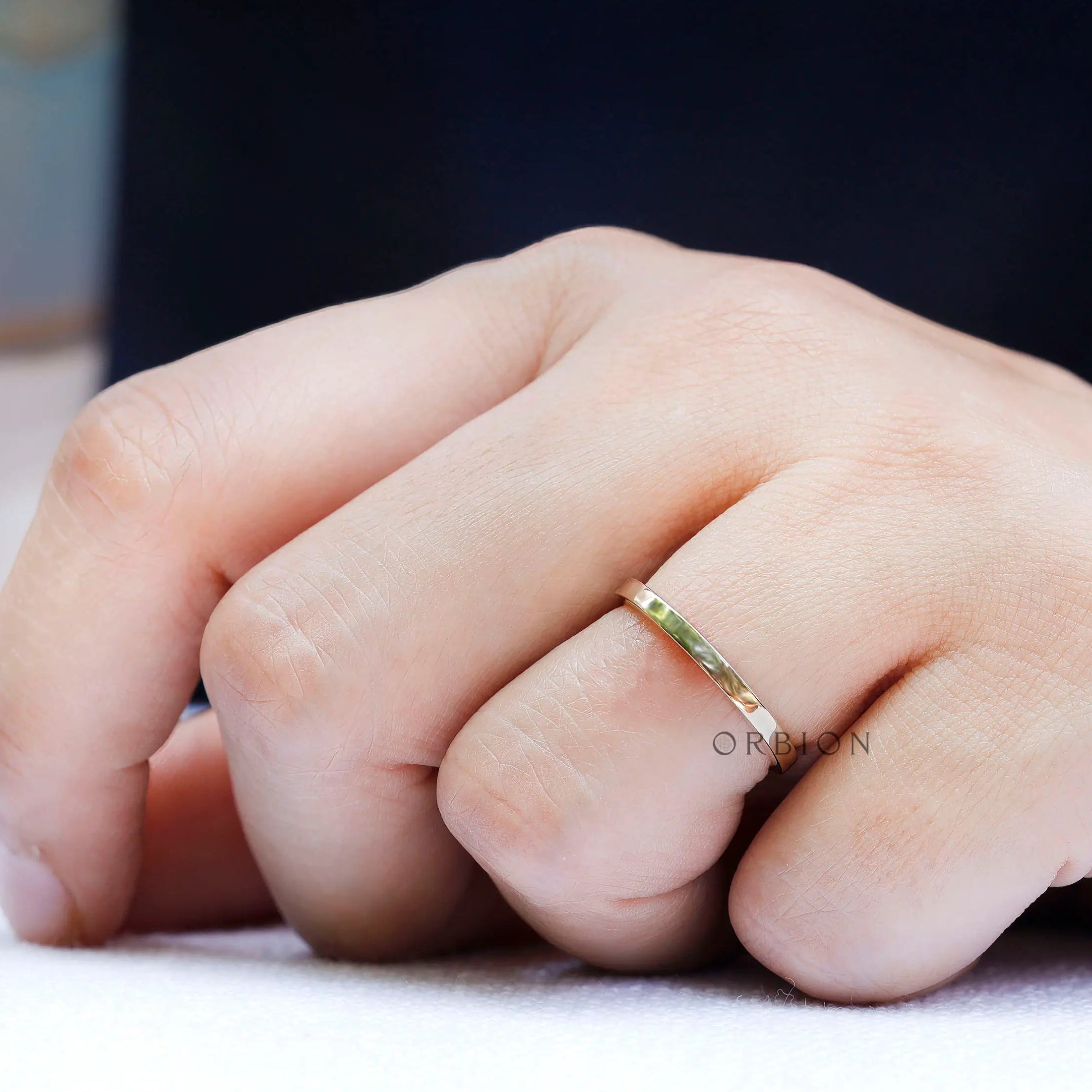 On-hand view of simple yellow gold wedding band