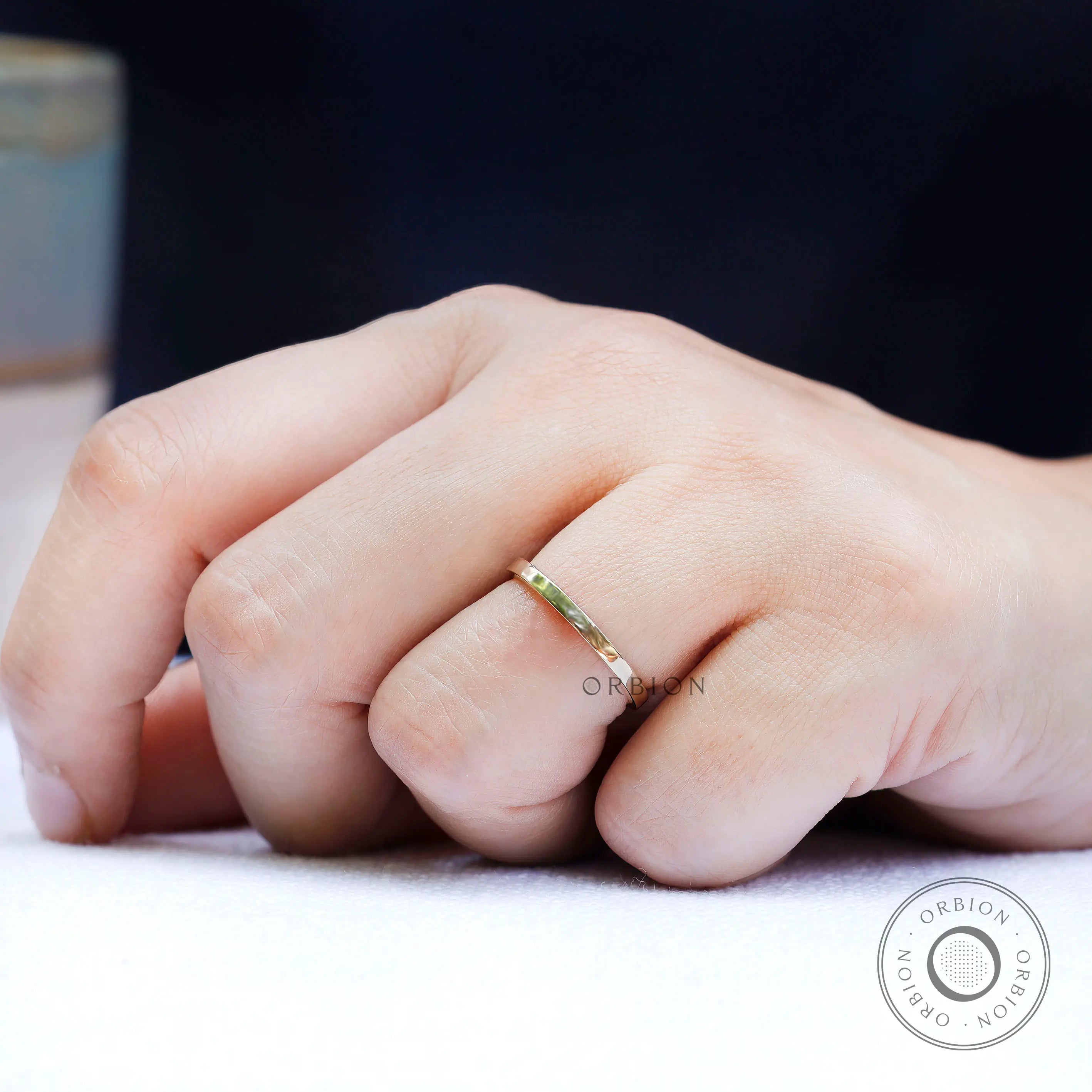 On-hand view of simple yellow gold wedding band