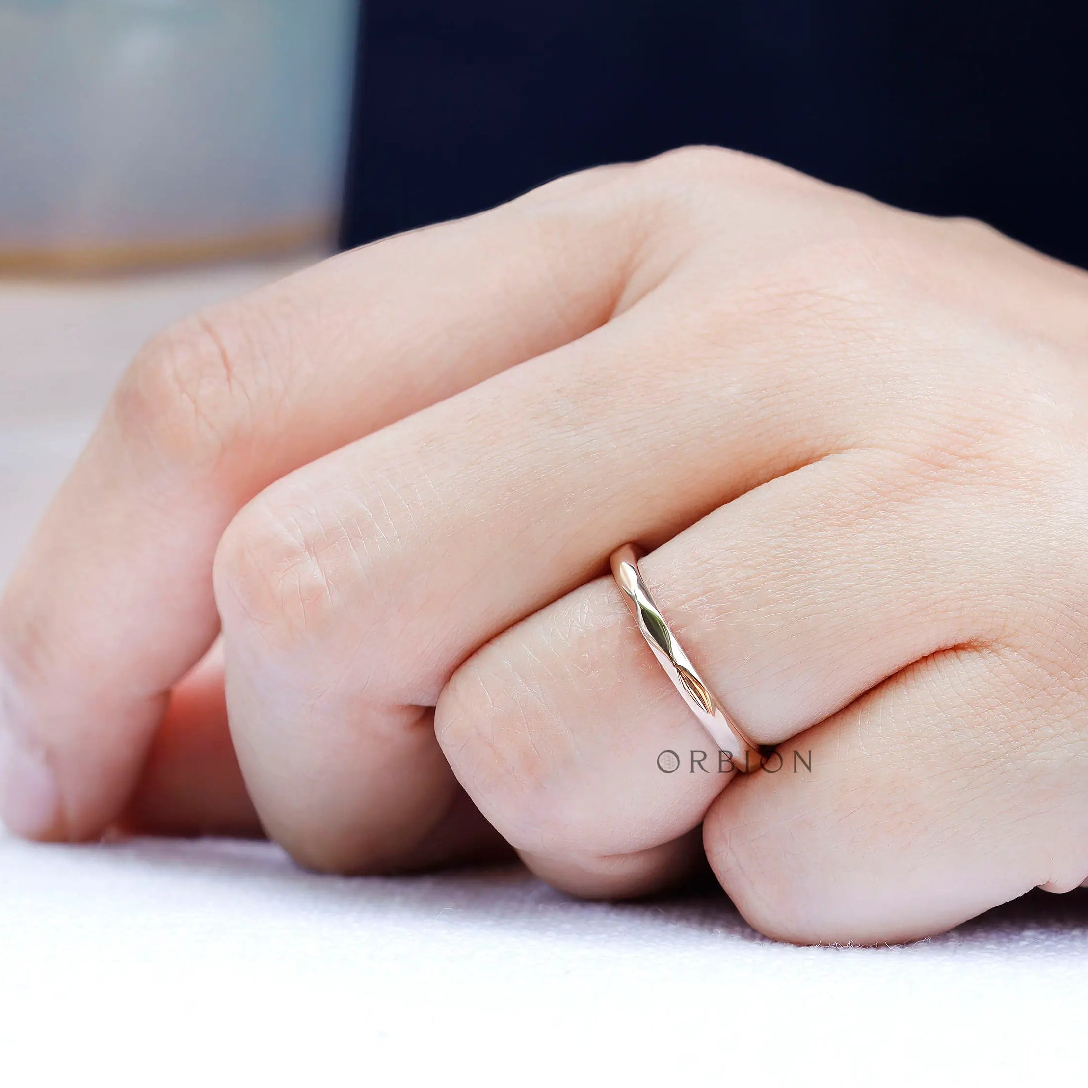 On-hand view of minimalist hammered rose gold band