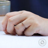 Thin Art Deco moissanite wedding band worn on hand