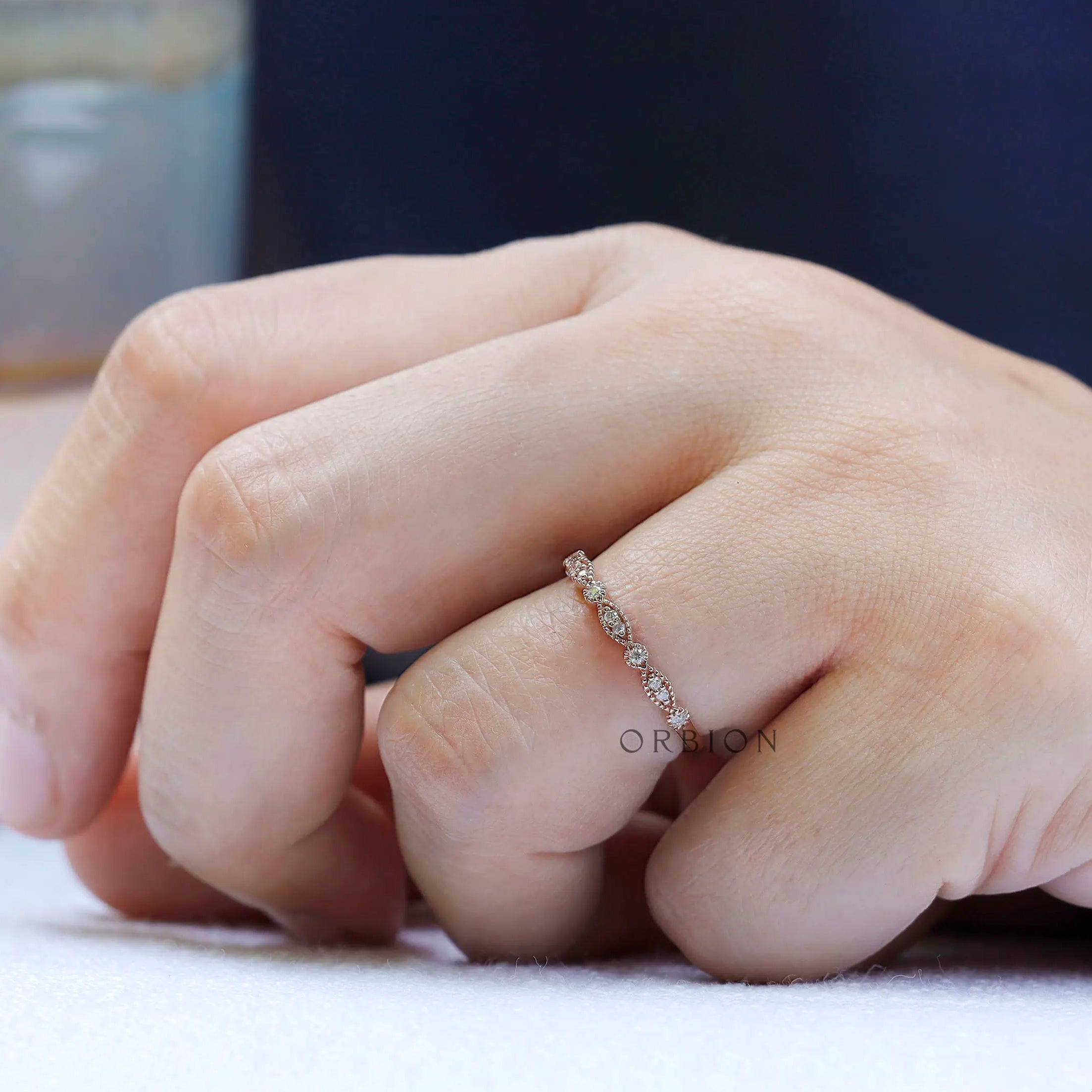 Thin Art Deco moissanite wedding band worn on hand