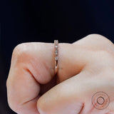 Close-up of marquise link and round moissanite milgrain band worn on finger