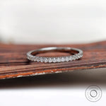Front close-up of pave set round stones on dainty wedding band