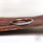 Angled view of minimalist pave wedding band with polished gold finish