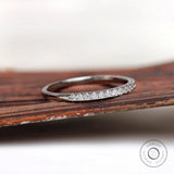 Angled view of minimalist pave wedding band with polished gold finish