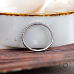 Side view of minimalist pave wedding band highlighting slim profile