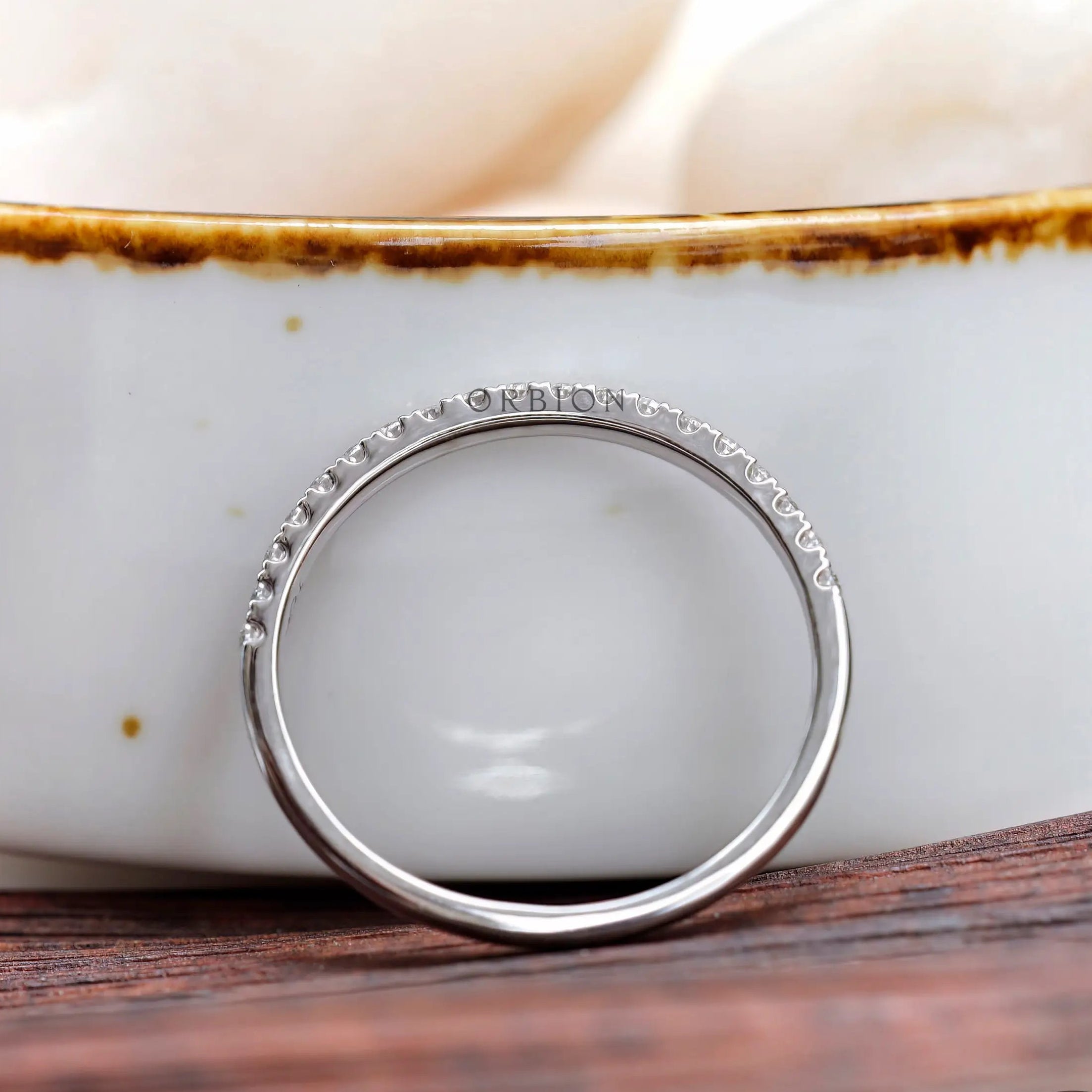 Side view of minimalist pave wedding band highlighting slim profile