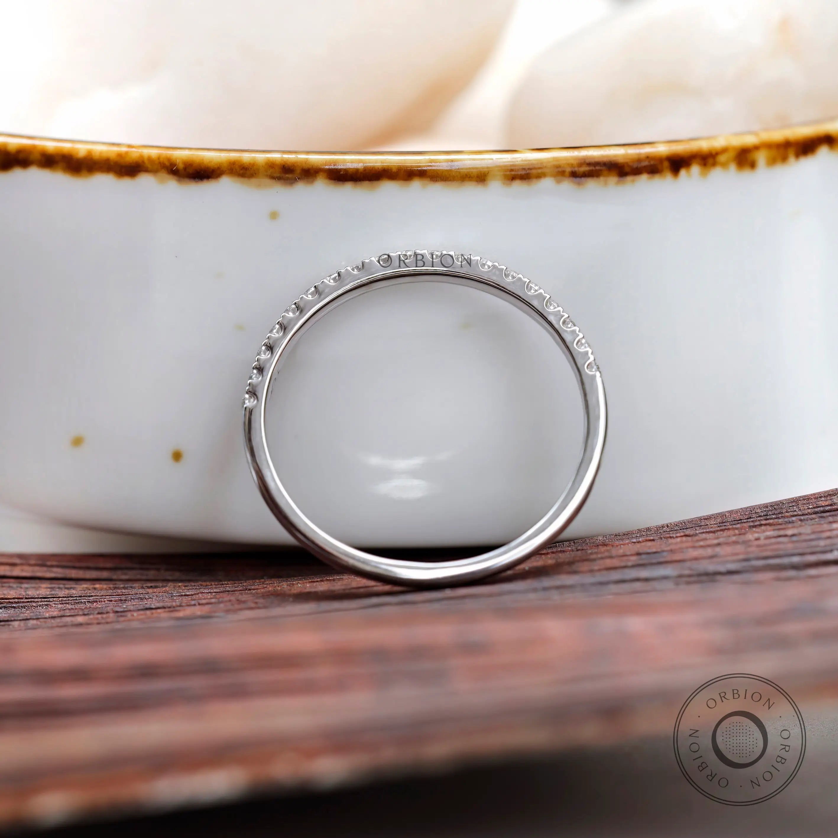 Side view of minimalist pave wedding band highlighting slim profile