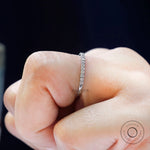 Worn on finger side view of dainty moissanite wedding band