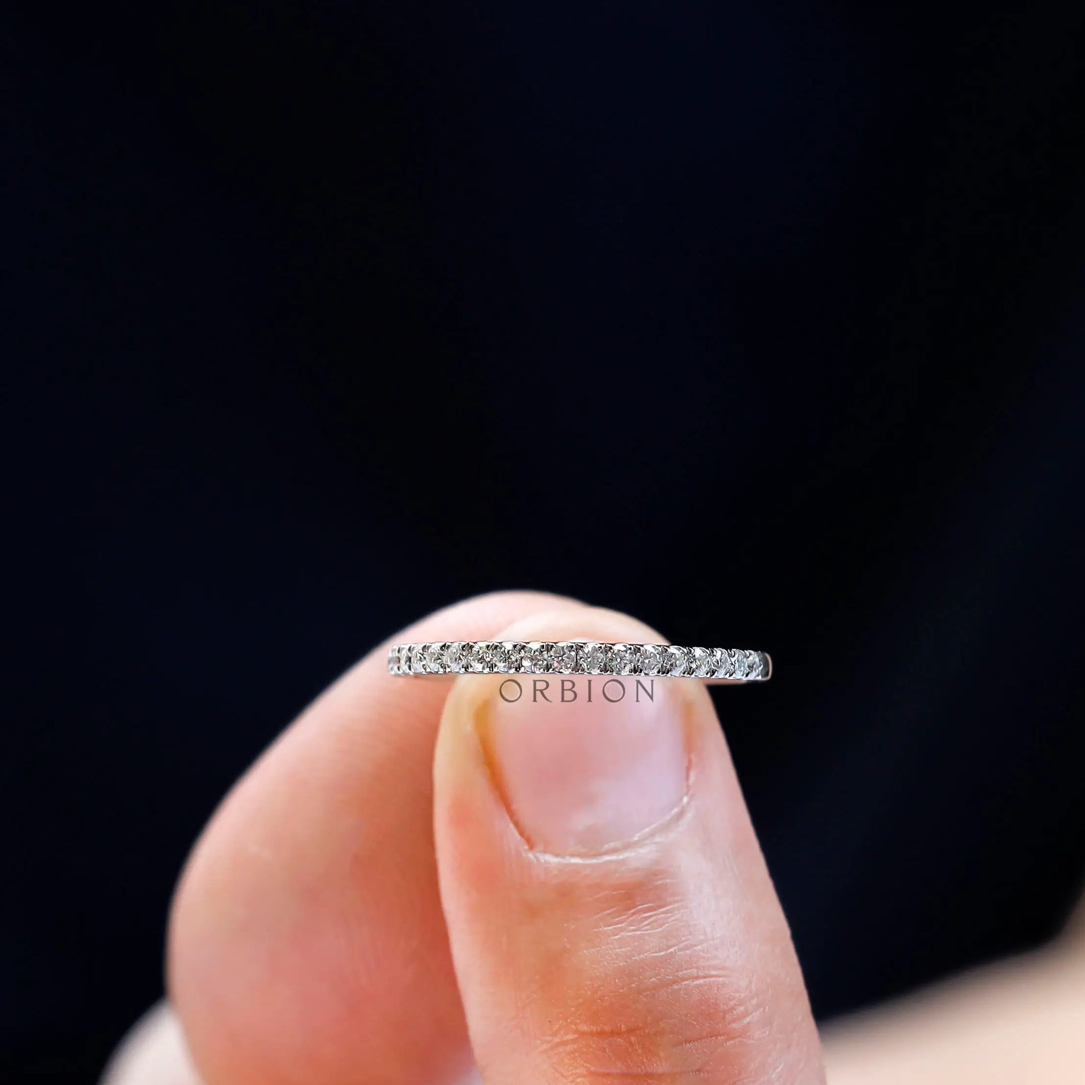 Minimalist pave moissanite wedding band hold on the finger