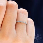 Close up view of the minimalist moissanite wedding band worn on finger