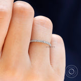 Close up view of the minimalist moissanite wedding band worn on finger