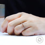 Slim marquise and round moissanite wedding band worn on hand