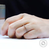 Slim marquise and round moissanite wedding band worn on hand