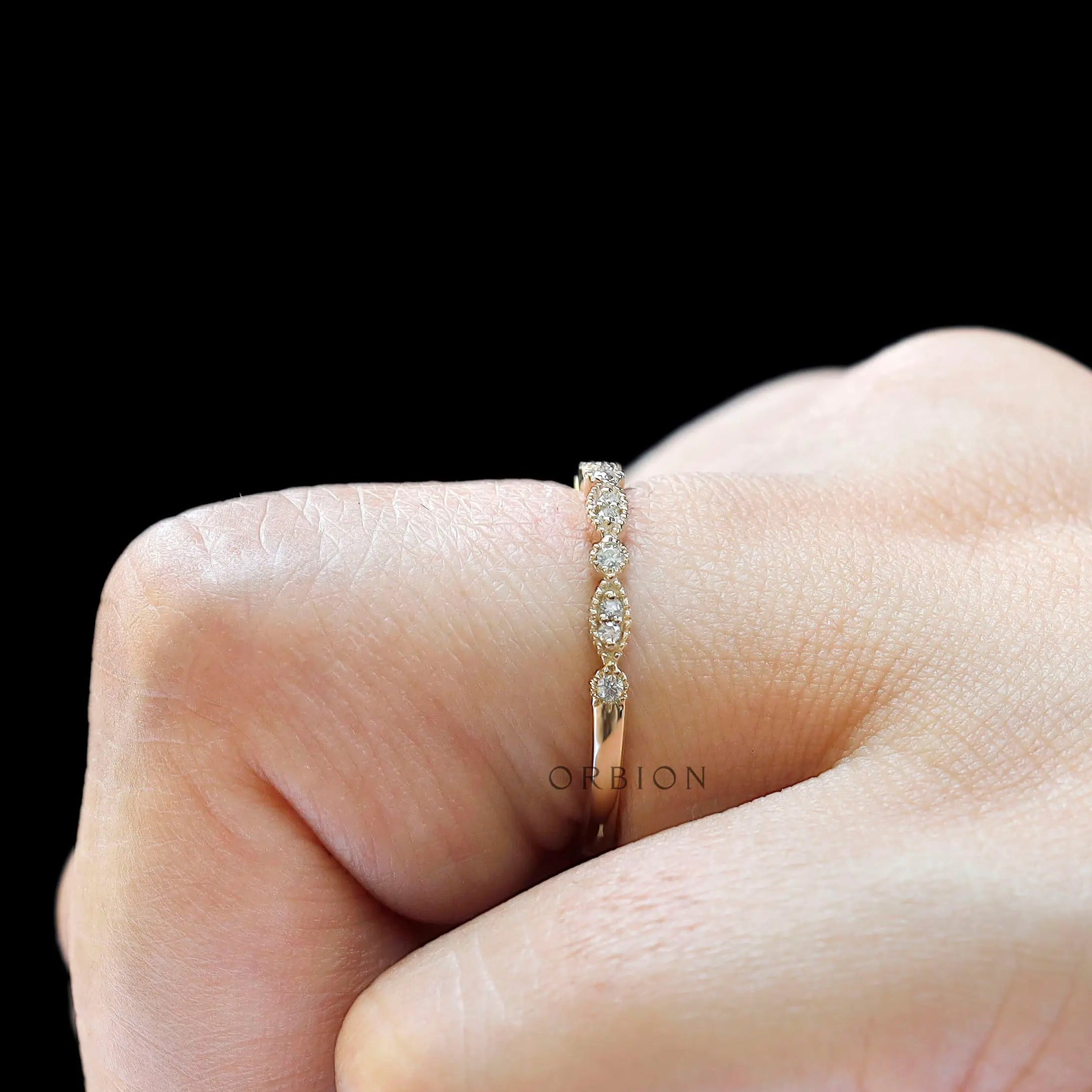 Close-up view of marquise link and round moissanite band highlighting milgrain details
