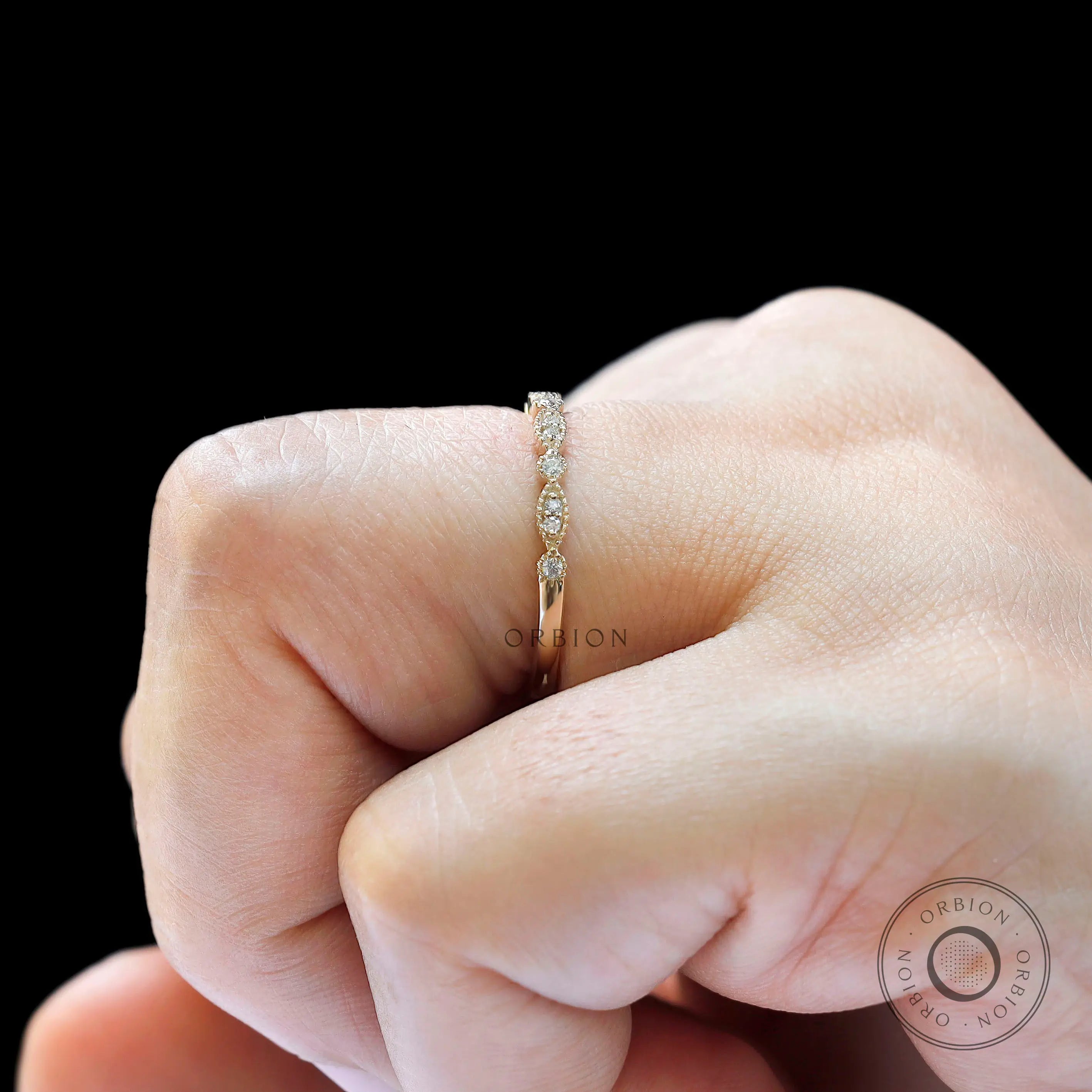 Close-up view of marquise link and round moissanite band highlighting milgrain details