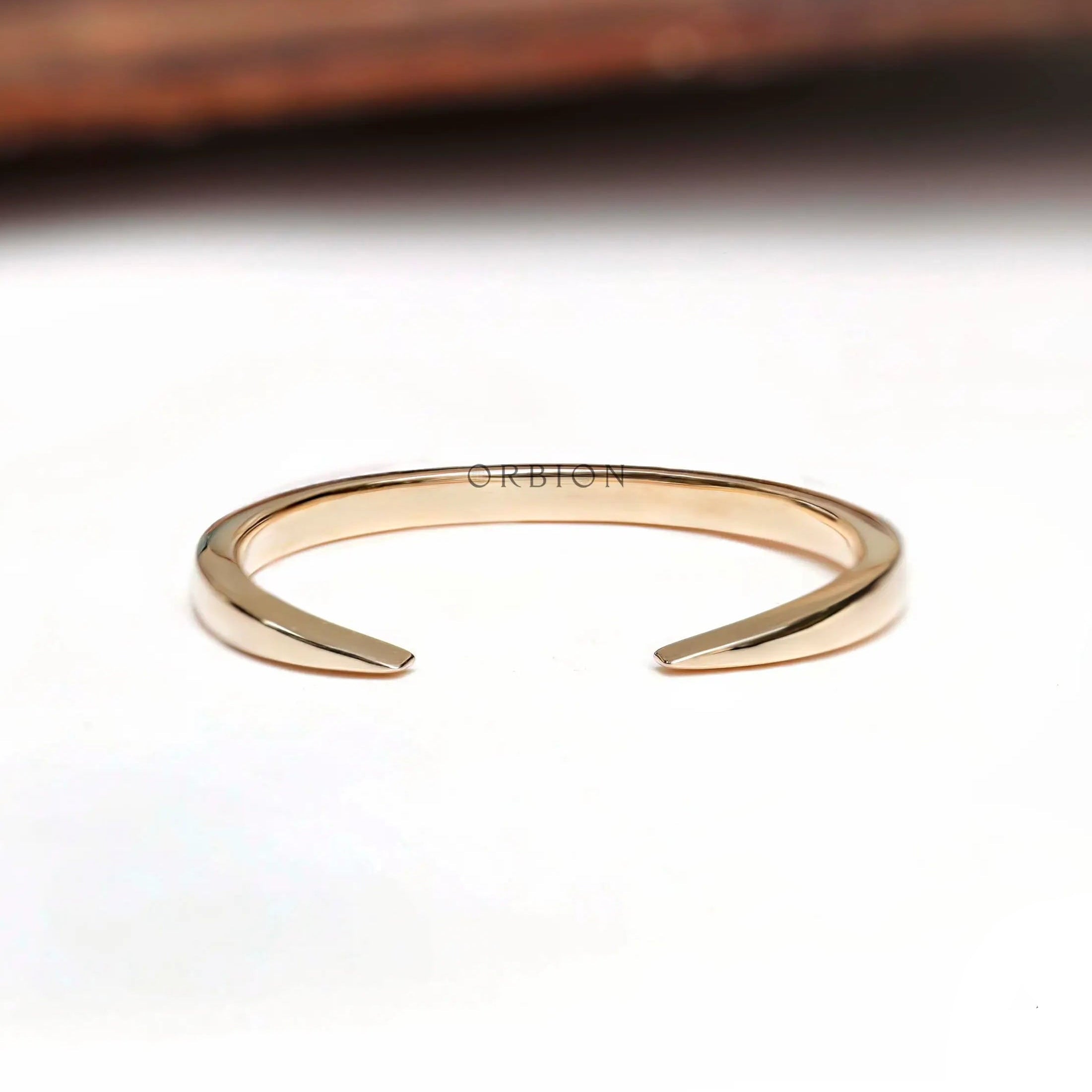 Minimalist open cuff claw wedding band angled view highlighting polished gold finish