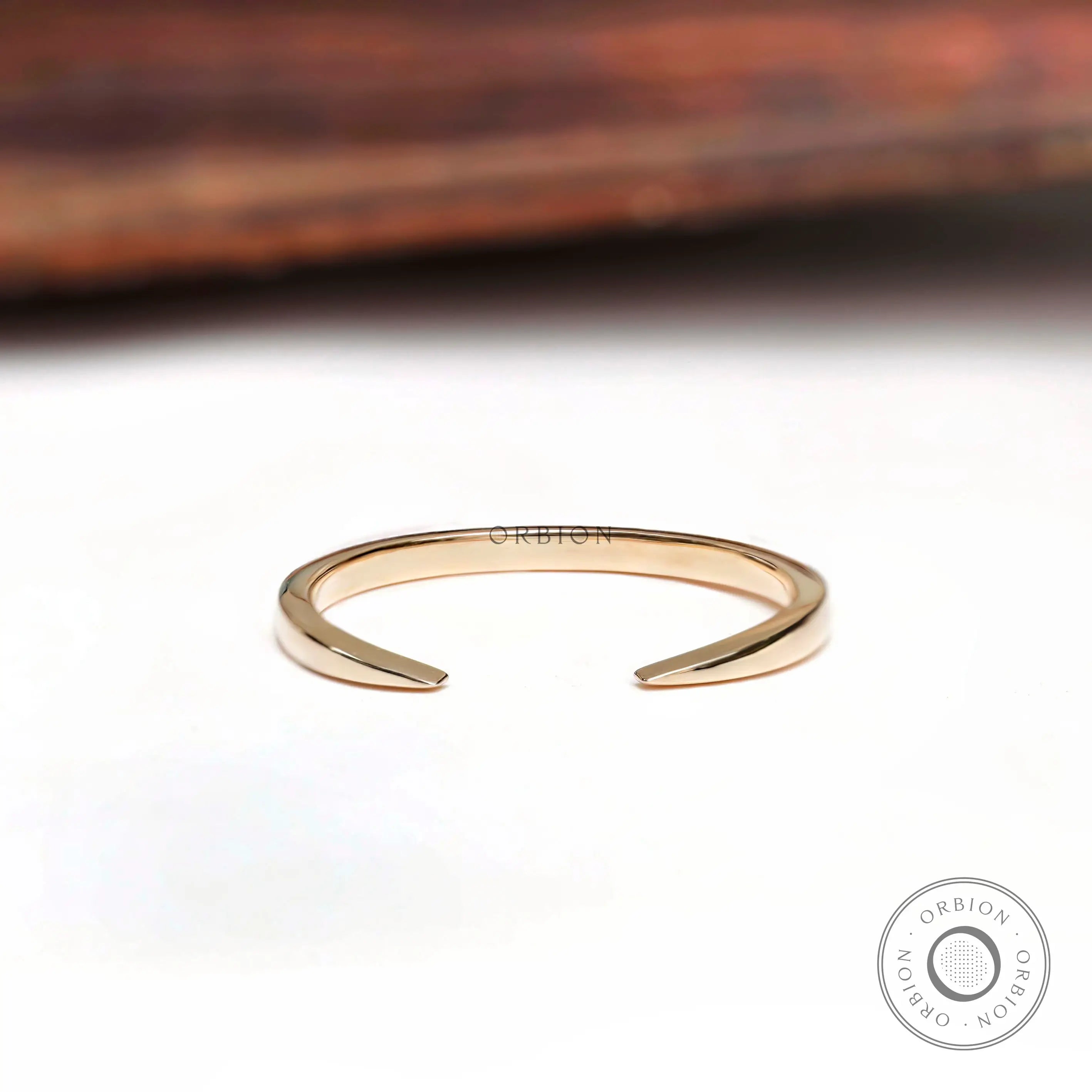 Minimalist open cuff claw wedding band angled view highlighting polished gold finish