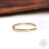 Side profile of solid gold open cuff wedding band showing tapered claw ends