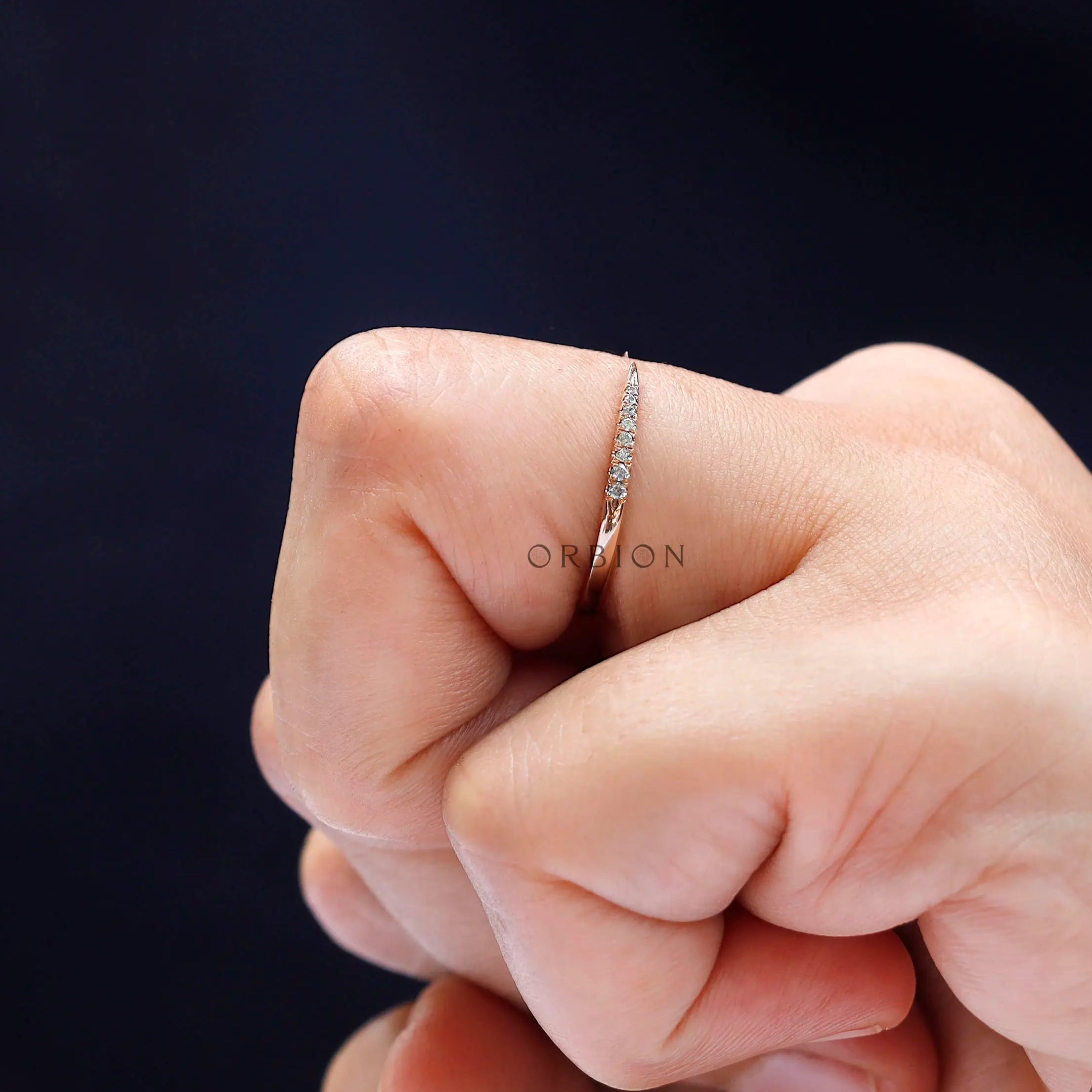 Side view of curved rose gold diamond band