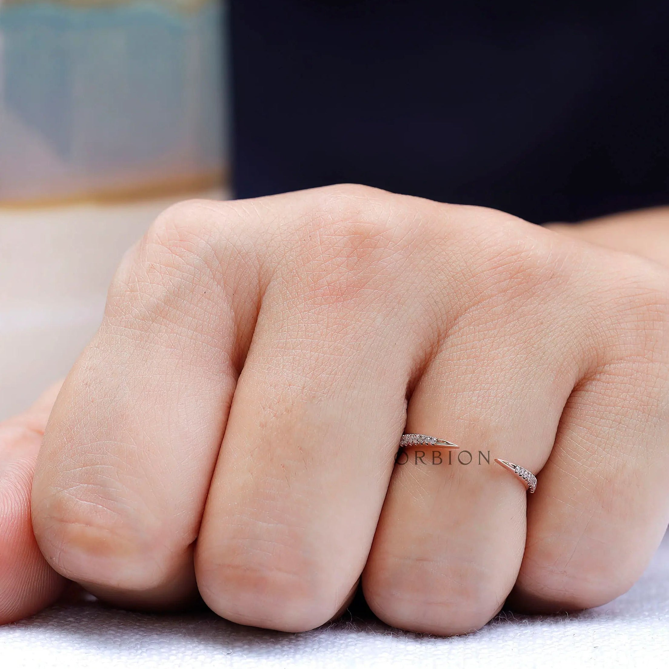 Delicate curved diamond band worn on hand