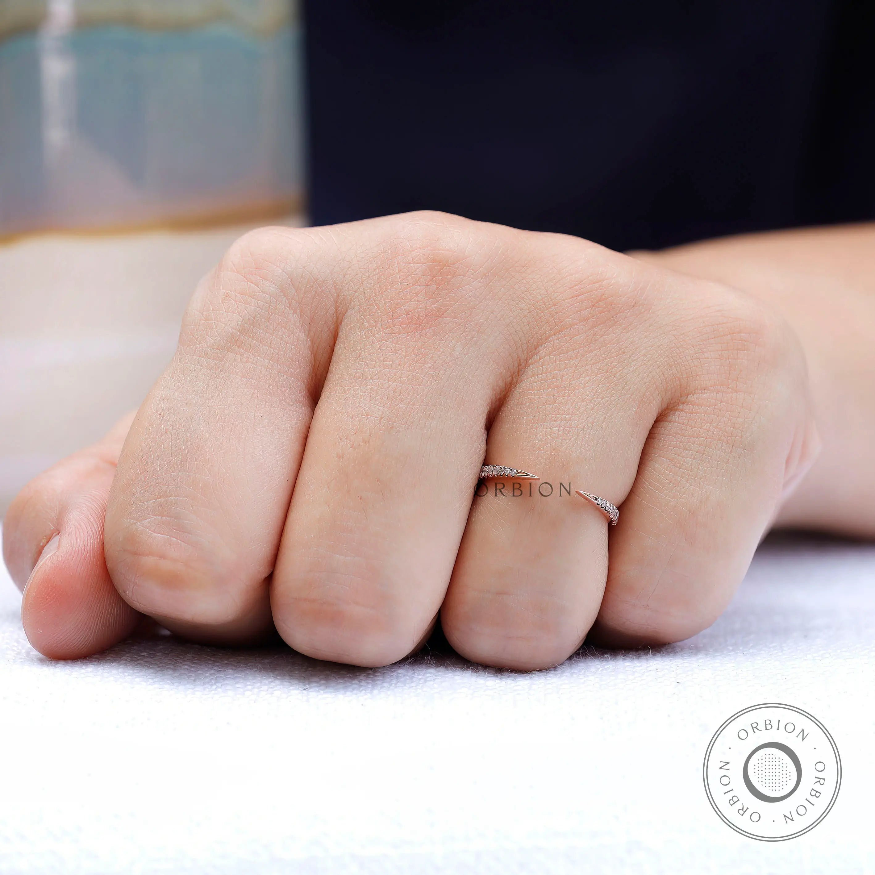 Delicate curved diamond band worn on hand