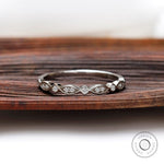 Front view of Art Deco half eternity band with marquise motif and round bezel accents.