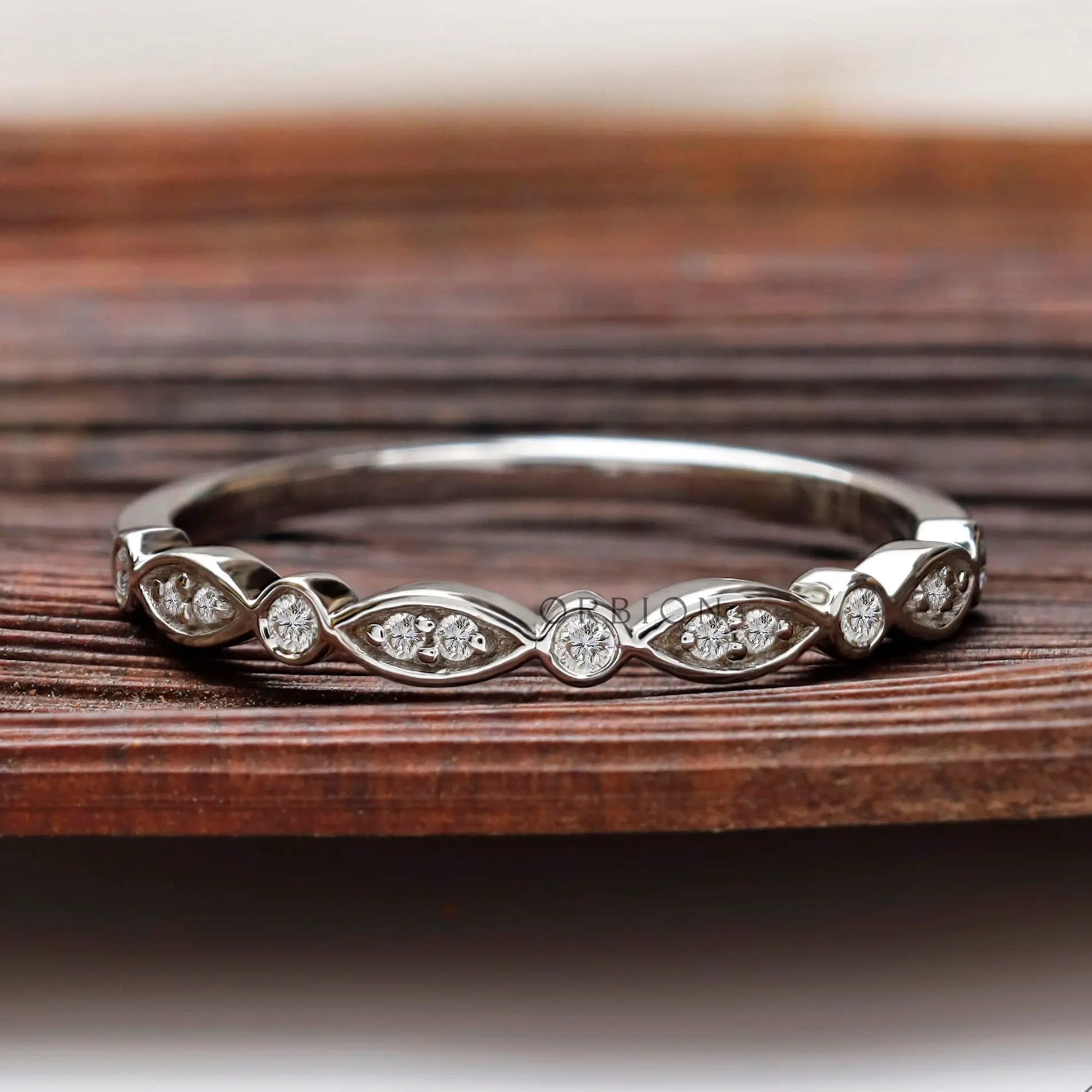 Front view of Art Deco half eternity band with marquise motif and round bezel accents.