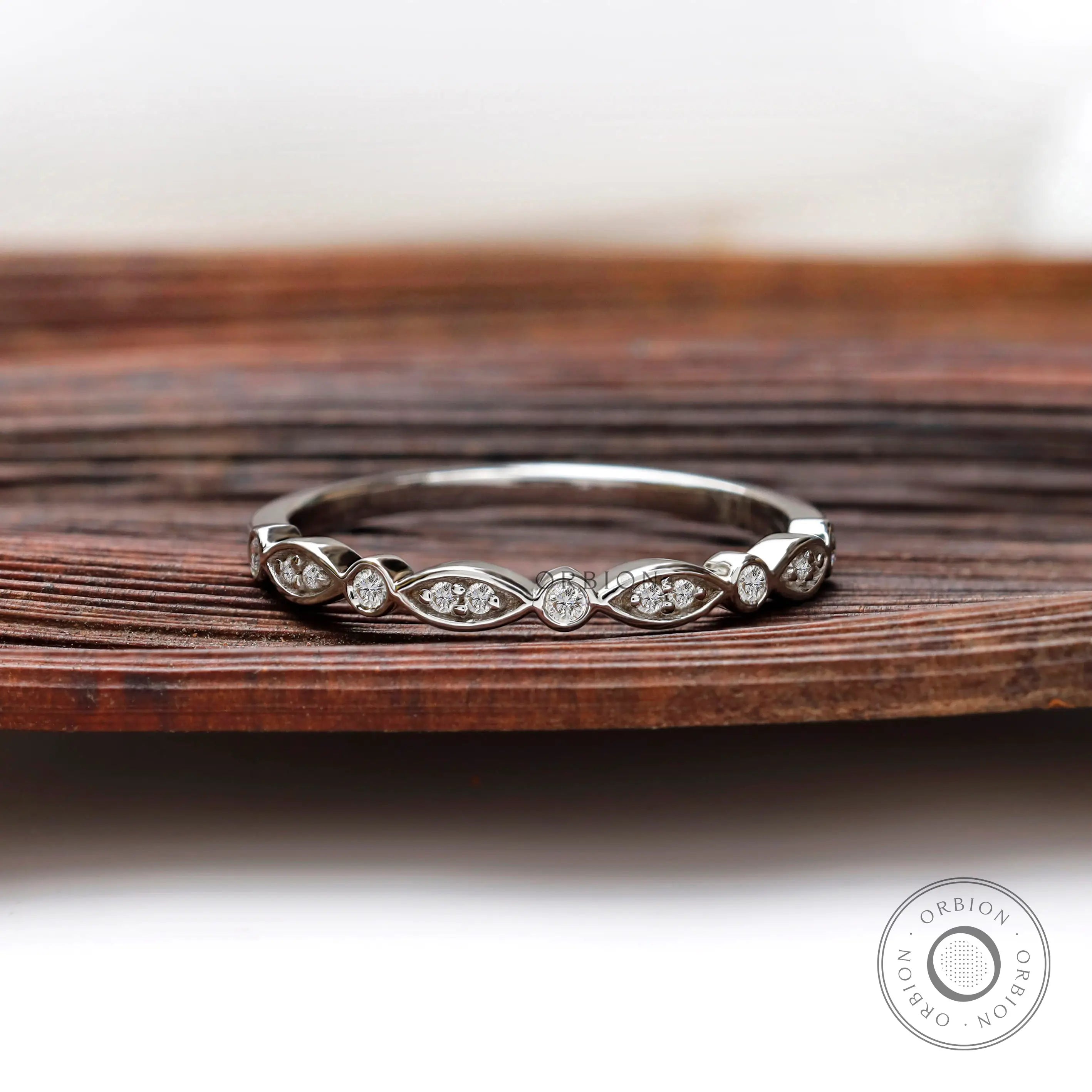 Front view of Art Deco half eternity band with marquise motif and round bezel accents.