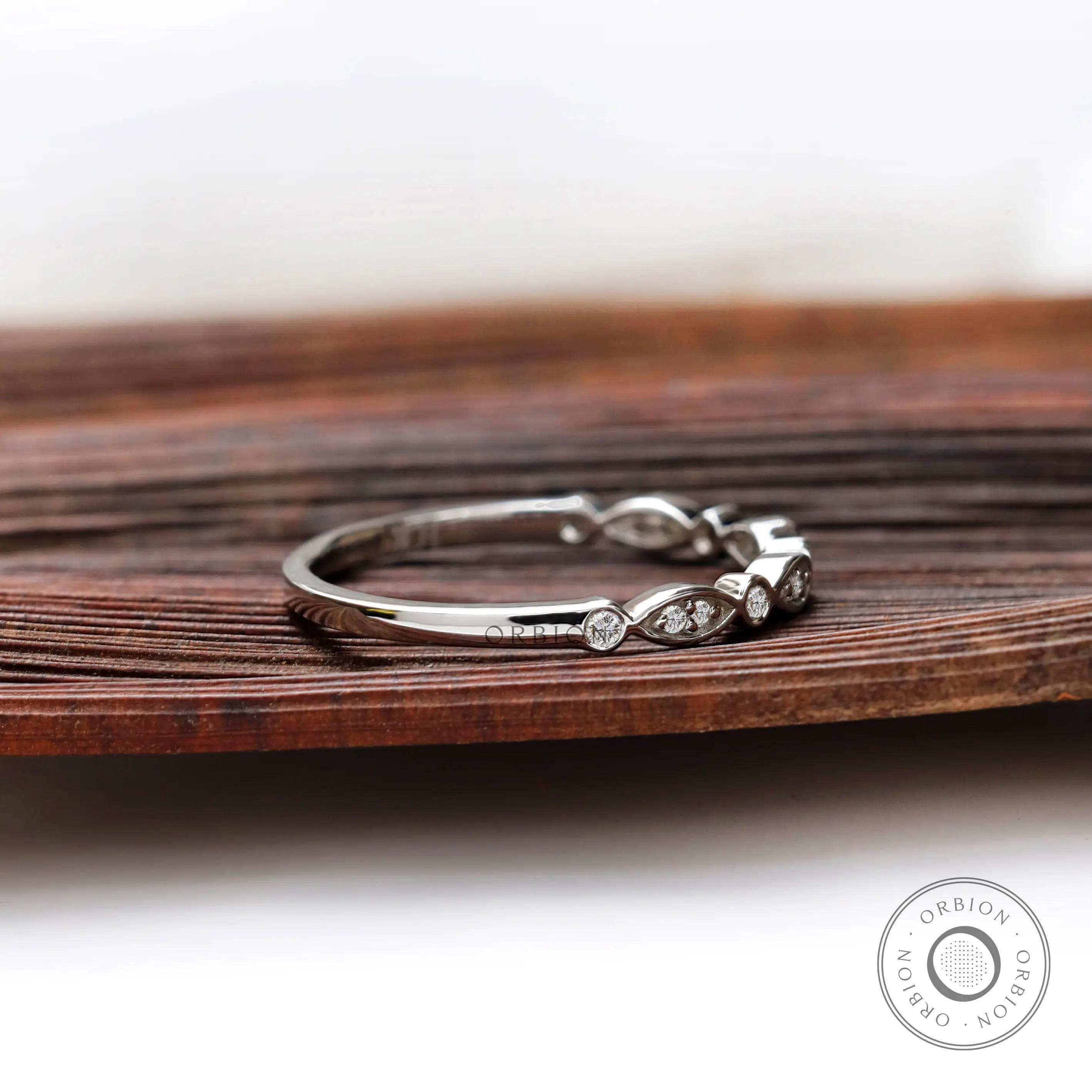Angled side view of Art Deco inspired wedding band showing alternating marquise bezel-set.