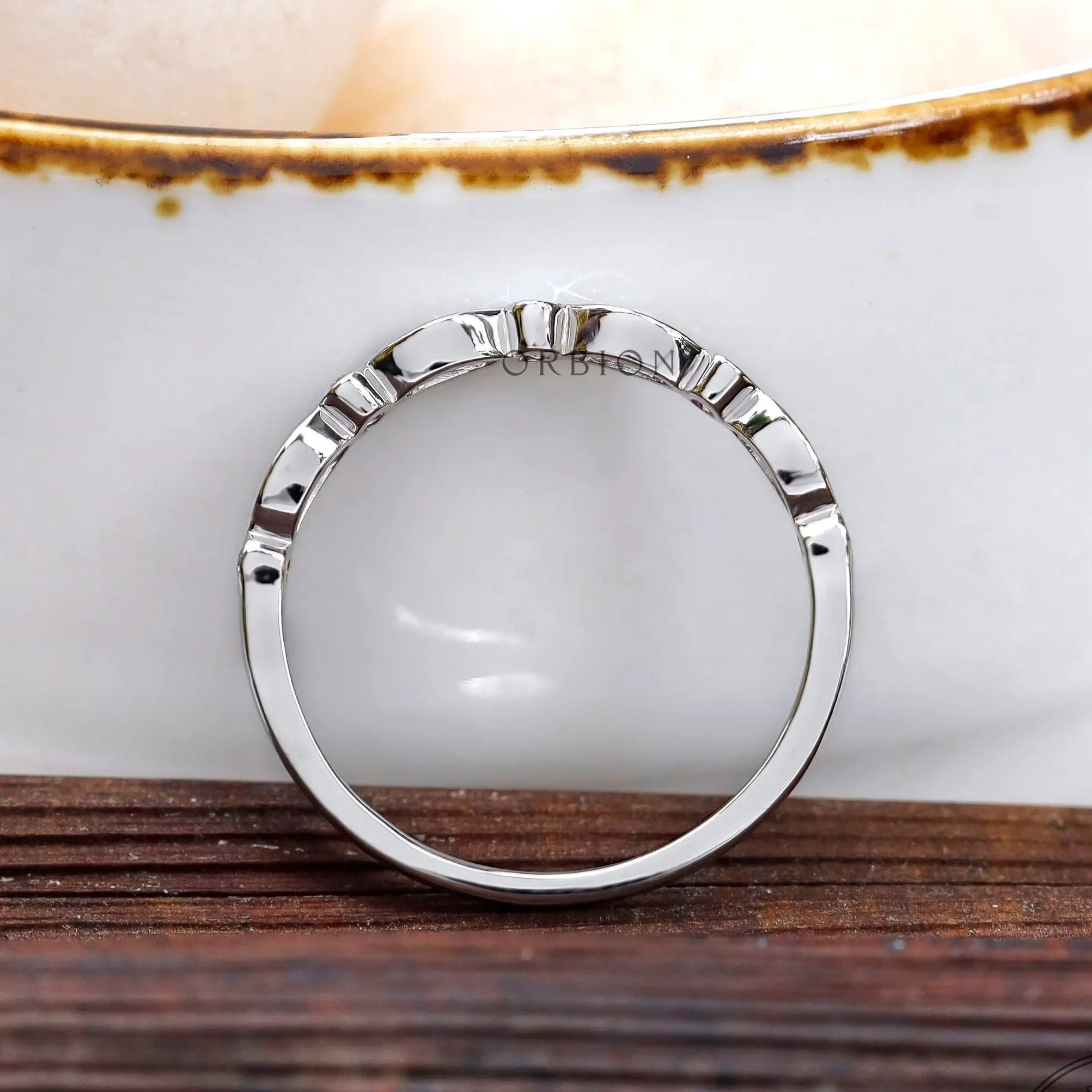 Side profile of vintage half eternity band highlighting the raised Art Deco pattern along the top.