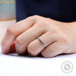 On-hand lifestyle photo of thin Art Deco wedding band with marquise detailing.