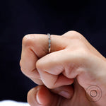 Close-up on finger showing marquise-and-round pattern of the half eternity band.