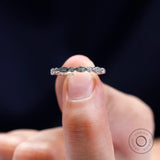 Close-up detail of vintage Art Deco moissanite band held between fingers.