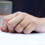 On-hand view of geometric moissanite wedding band
