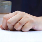 On-hand view of geometric moissanite wedding band