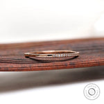 Side angled view of slim pave moissanite diamond stacking band