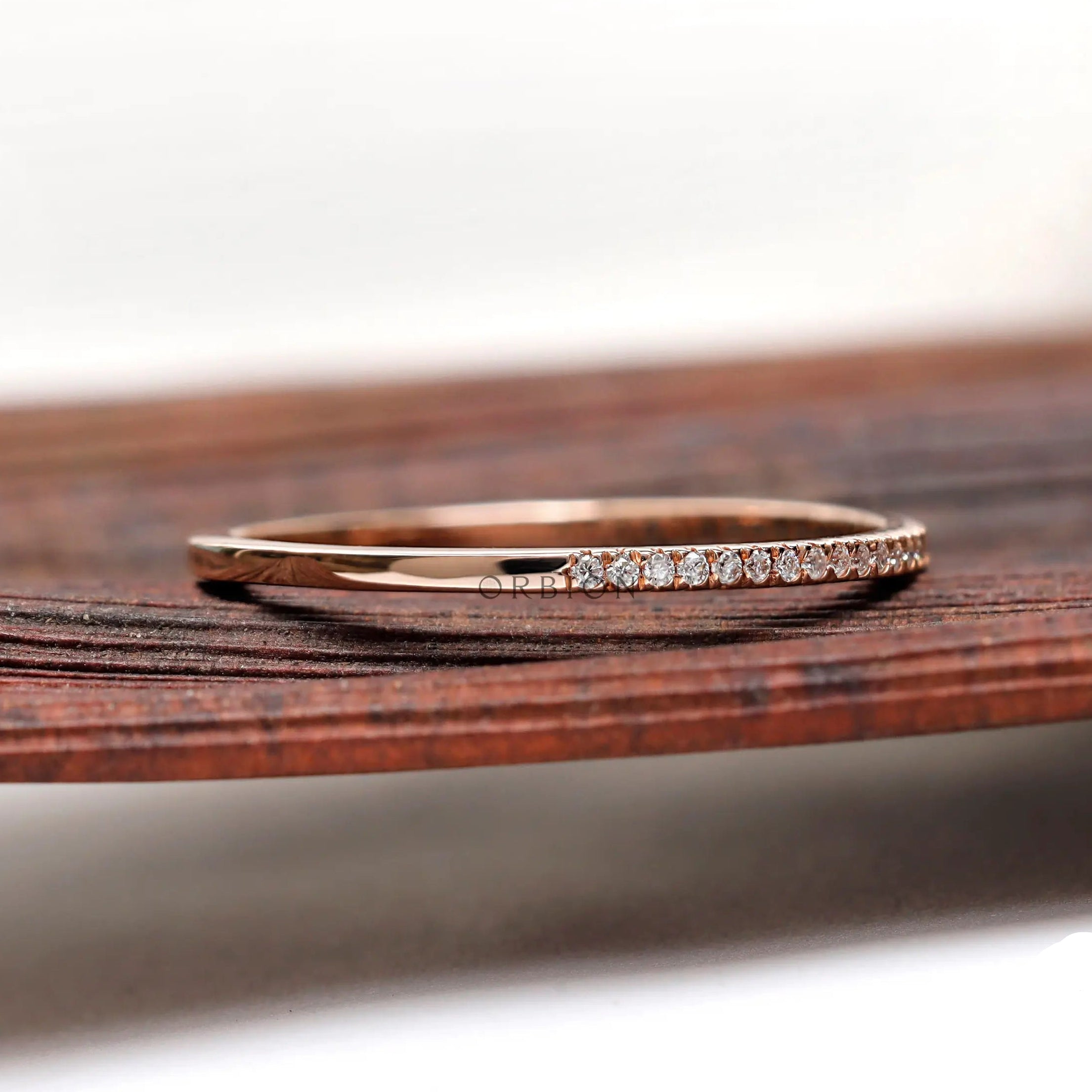Side angled view of slim pave moissanite diamond stacking band
