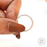 Slim pave moissanite wedding band held between fingers showing detail