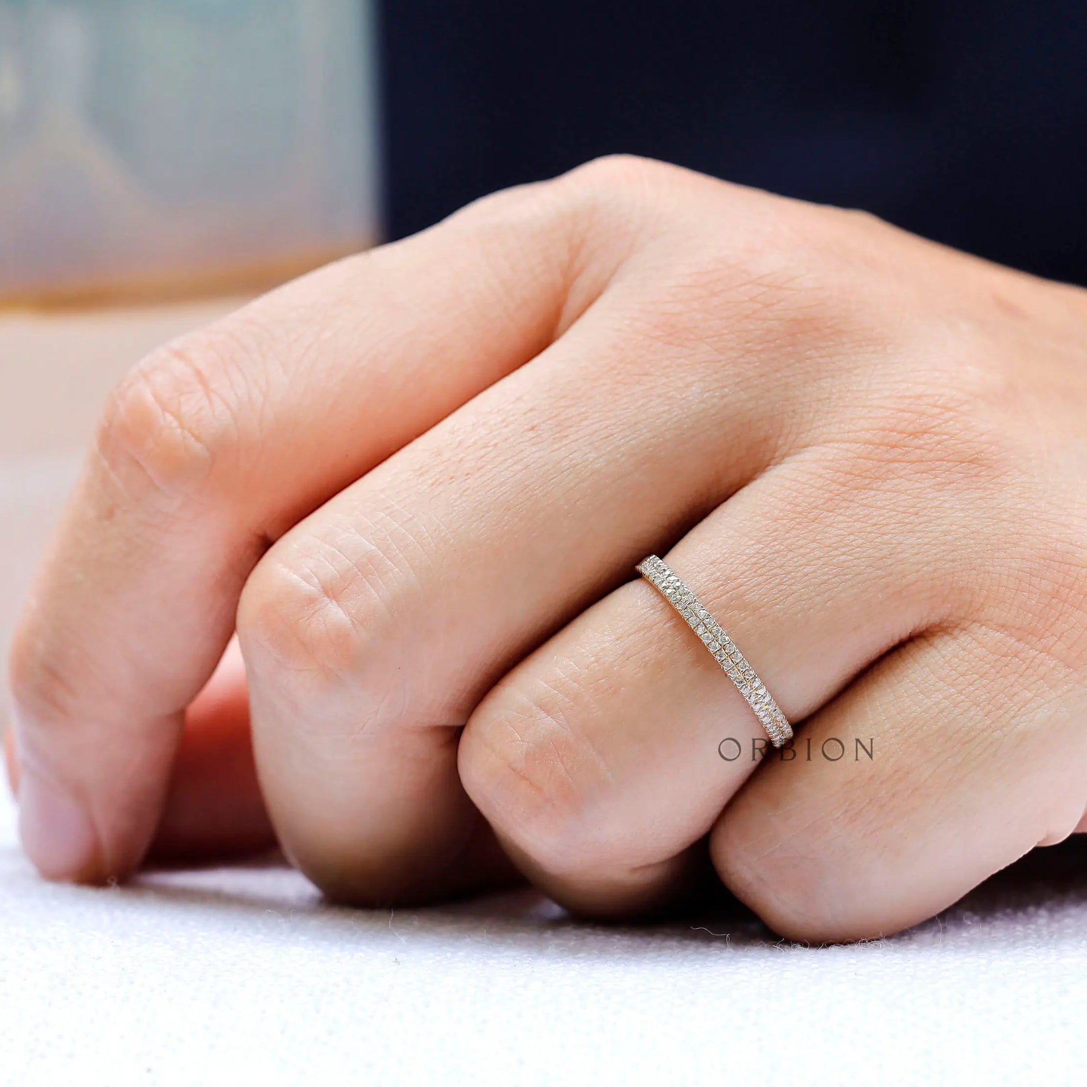 On hand view of minimalist pave wedding band