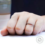 On-hand lifestyle photo of delicate geometric wedding band in a slim stacking style.