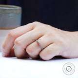 Angled on-hand view showing the sparkle of bezel-set round accents and oval.