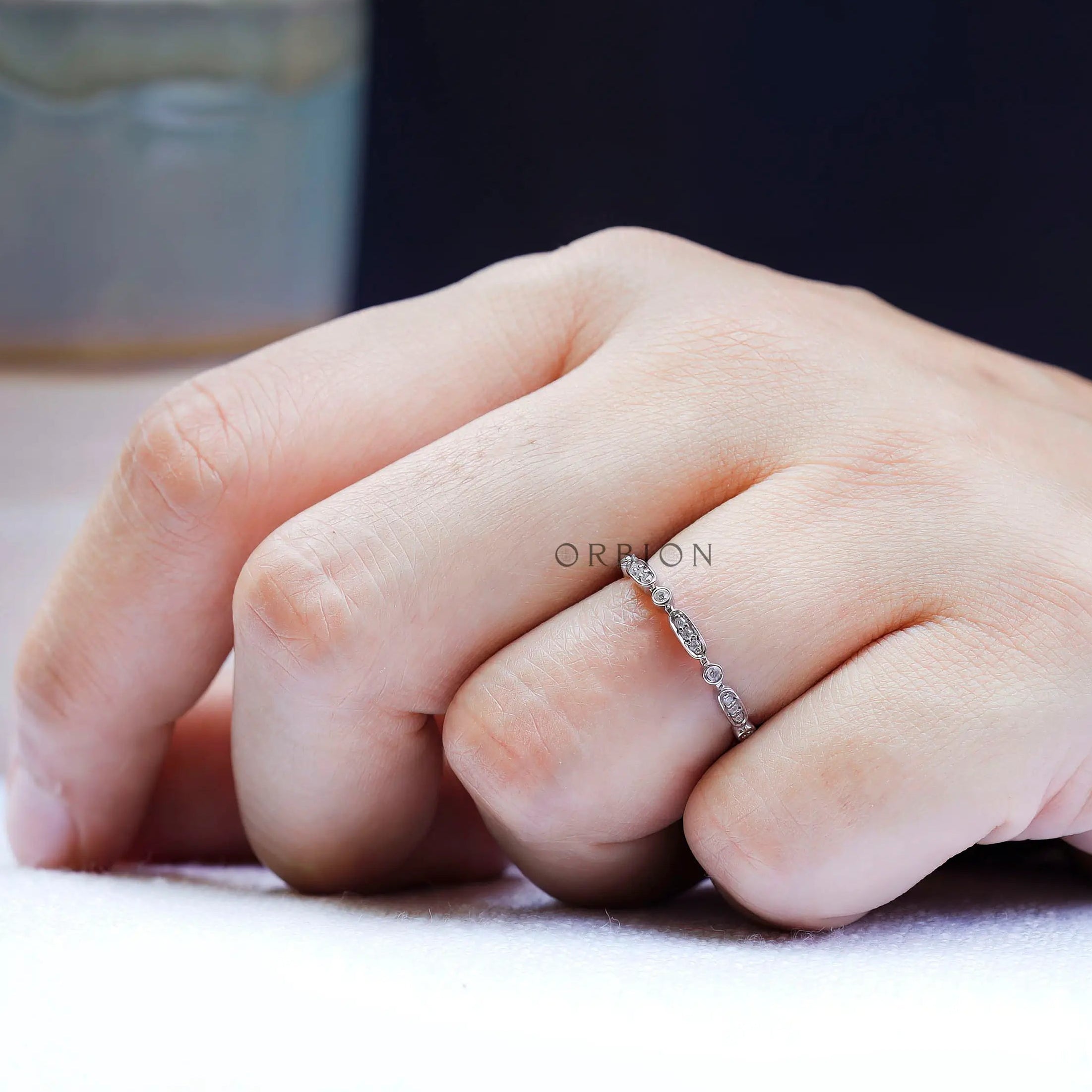 Angled on-hand view showing the sparkle of bezel-set round accents and oval.