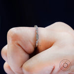 Close-up on finger showing the geometric pattern with round bezel accents.
