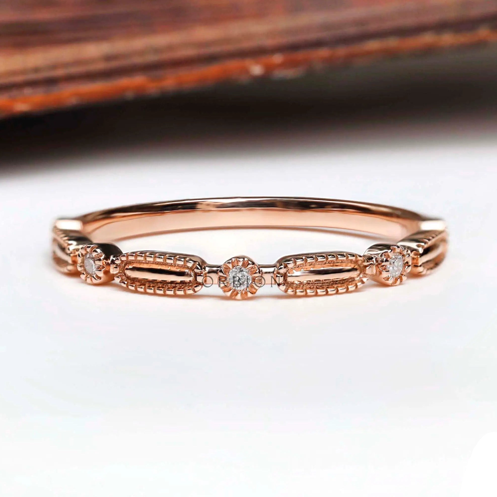 Front view textured geometric wedding band with round stones in rose gold
