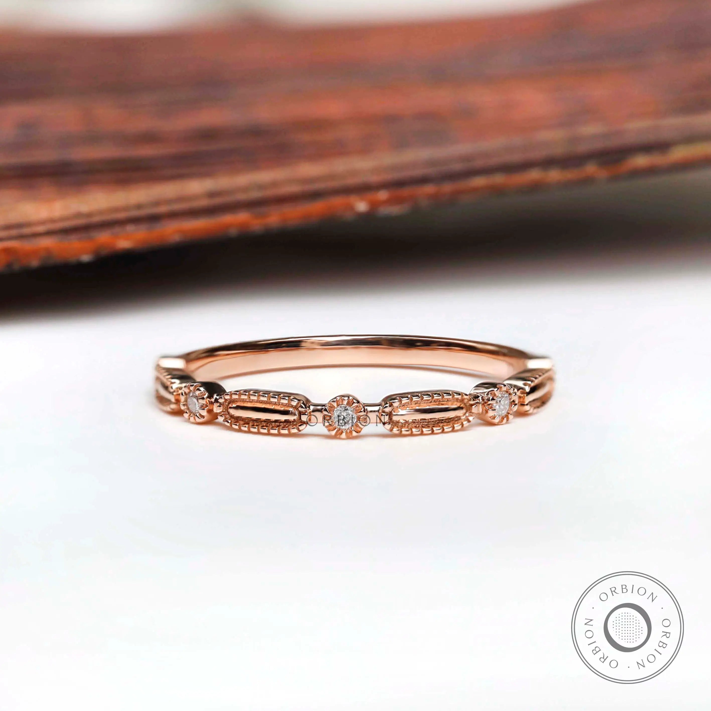 Front view textured geometric wedding band with round stones in rose gold