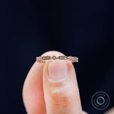 Close-up on finger geometric textured stacking band with round stones